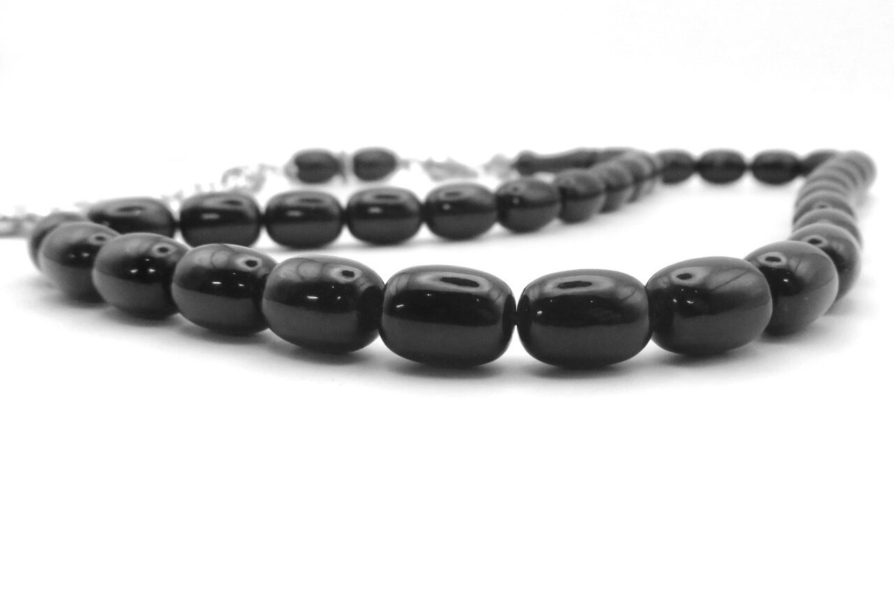 a close up on black oval onyx rosary beads